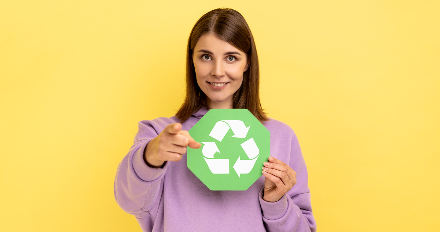Zadowolona kobieta trzymająca znaczek recyklingu