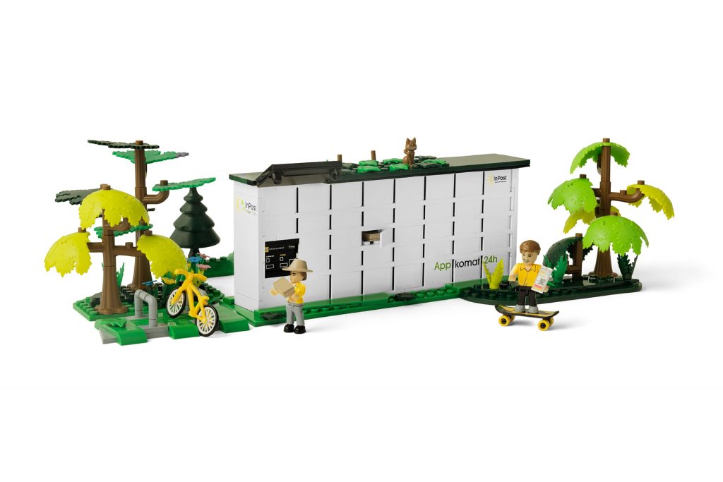 Zdjęcie przedstawia złożone klocki, z których powstał Paczkomat wraz z mały miasteczkiem wokół