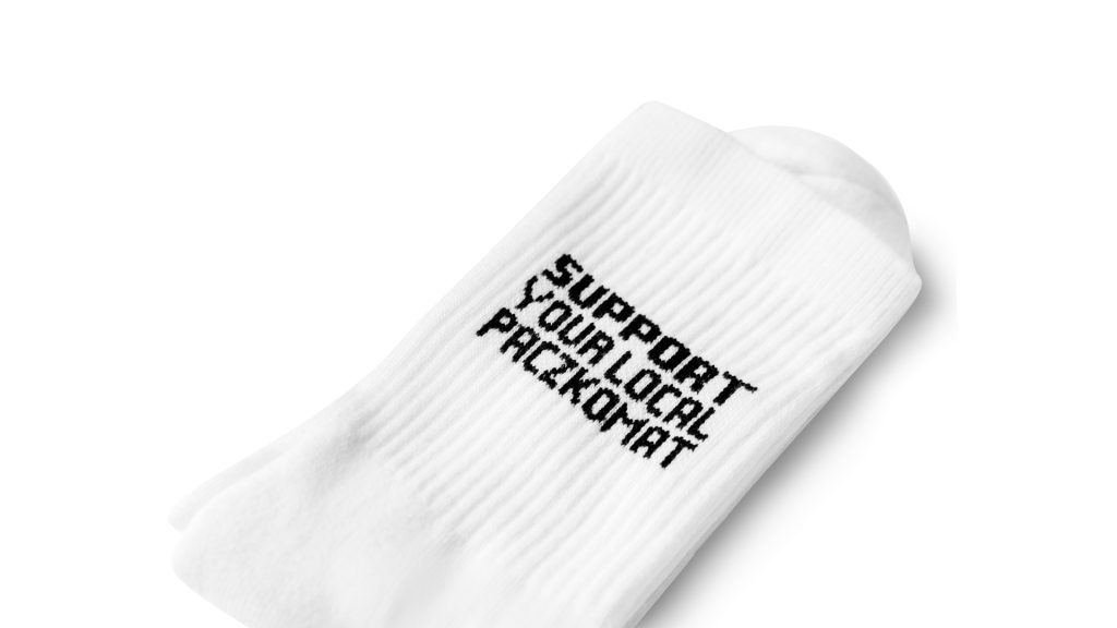 Długie białe skarpetki ze ściągaczem na górze z czarnym napisem SUPPORT YOUR LOCAL PACZKOMAT