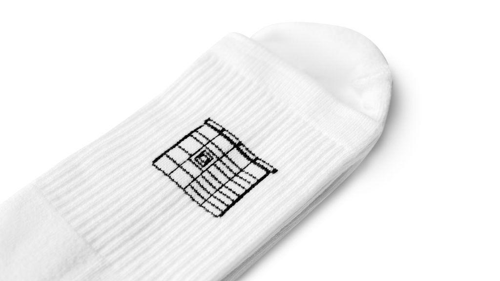 Długie białe skarpetki ze ściągaczem na górze z czarnym wzorem maszyny paczkomat.