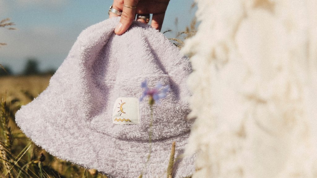 Fioletowy kapelusz z naszywką logotyp InPost i Surf