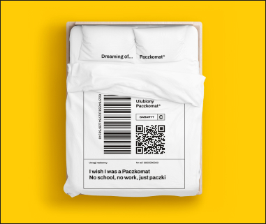 Pościel od InPost ze wzorem etykiety nadawczej oraz z napisem "dreaming of paczkomat" na poduszkach.