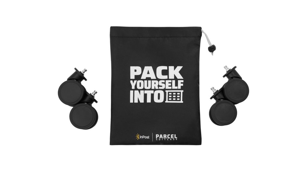 Czarna torba na kółka z napisem "PACK YOURSELF INTO" i ikoną maszyny Paczkomat i czterema czarnymi kółkami do walizki.